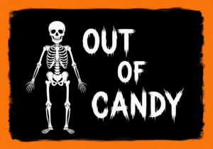A black sign with an orange border. There is a white skeleton on the right and on the left white text reads "out of candy"